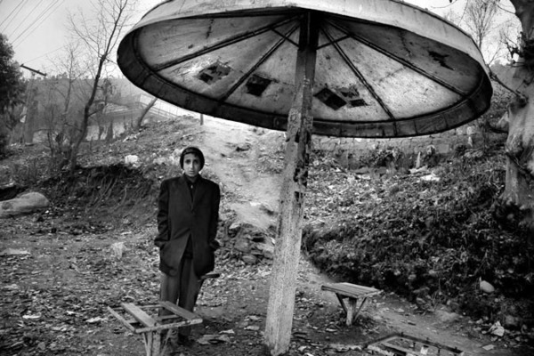 12 year old Mabashar hiding for the rain by the Neelum river in Muzzafarabad : Short Stories : Charlotte Oestervang Photography