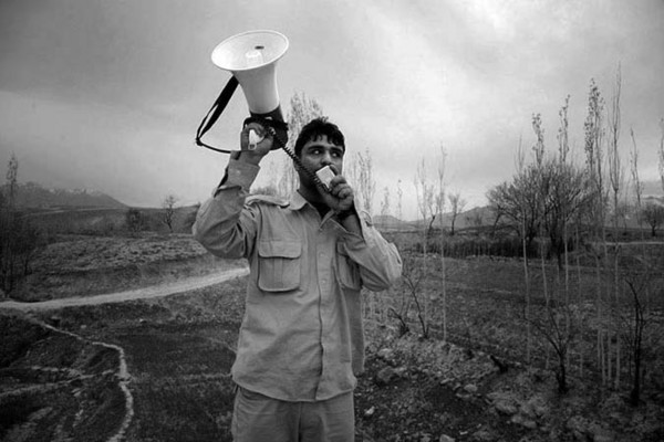 Village-by-Village clearance operations. Explosives Ordnance Disposal (EOD) operator Ajmal is announcing the Teams presence outside of the village Dakow Ye Payan close to Kabul. EOD Teams are systematically clearing village after village in all appointed districts and provinces : Demining in Kabul : Charlotte Oestervang Photography